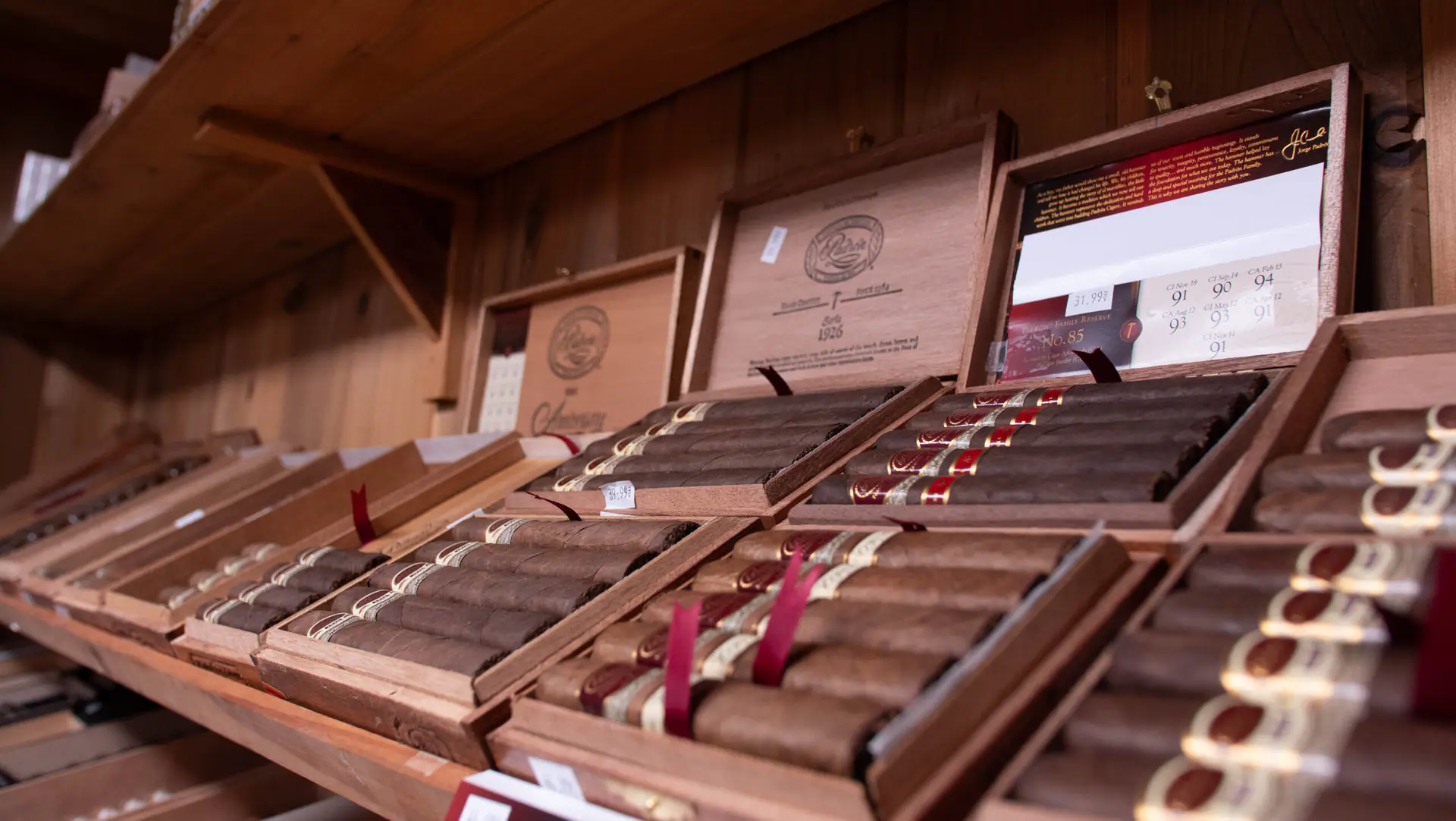 Open boxes of Padrón cigars on cedar shelves in the walk-in humidor
