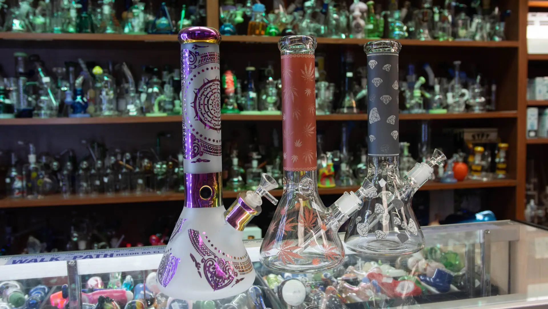 Three decorated glass beaker water pipes on the display counter