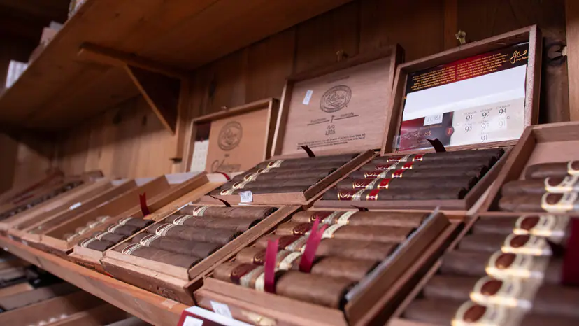 Open boxes of Padrón cigars on cedar shelves in the walk-in humidor